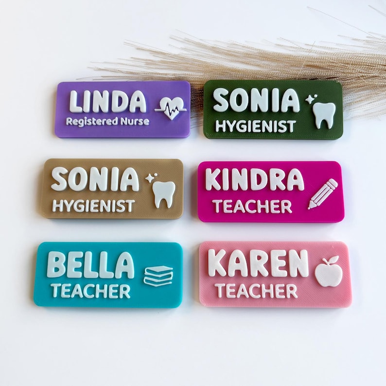 May include: Six rectangular name badges in purple, dark green, tan, magenta, teal, and pink. Each badge features raised white lettering and icons including a heart-pulse, tooth, pencil, books, and apple, displaying names like Linda, Sonia, Kindra, Bella, and Karen.