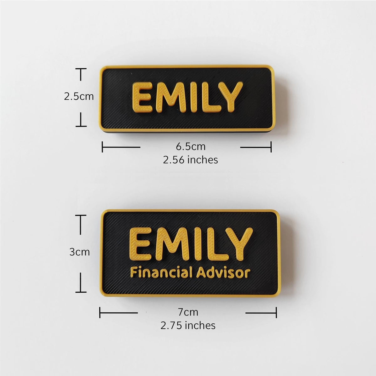 May include: Two black name badges with gold lettering. The top badge reads "EMILY" and measures 6.5cm long. The bottom badge reads "EMILY Financial Advisor" and is 7cm long. Both badges have a gold border.
